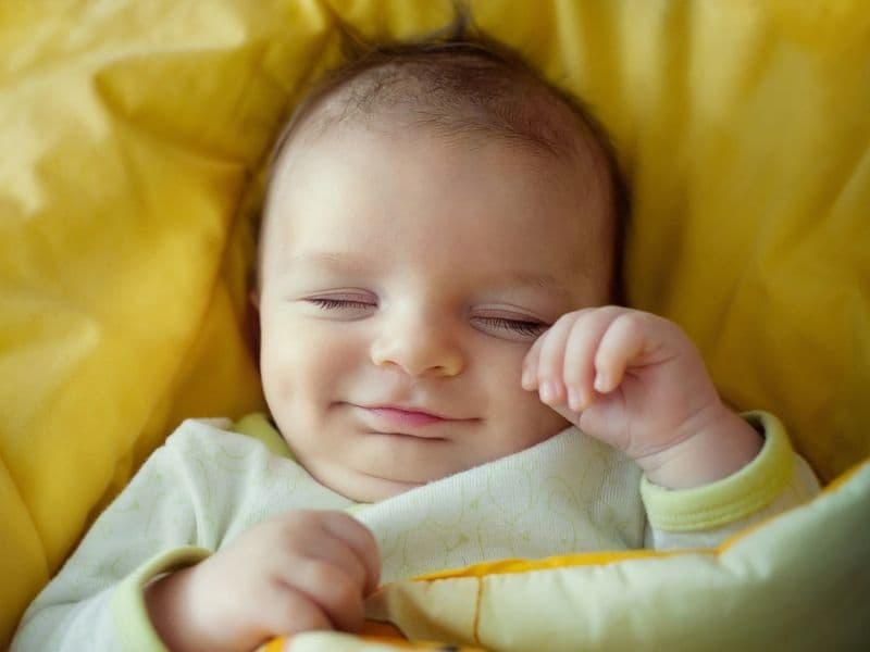 Ngủ mà miệng vẫn cười là một trong 6 tư thế ngủ của trẻ sơ sinh thông minh. (Ảnh: Sưu tầm Internet)