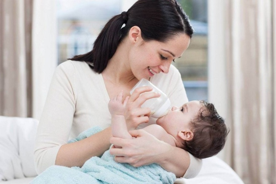 Khi cho bé bú bình mẹ nên giữ đầu bé ở vị trí cao hơn thân để dễ tiêu hóa sữa (Ảnh: Sưu tầm Internet)