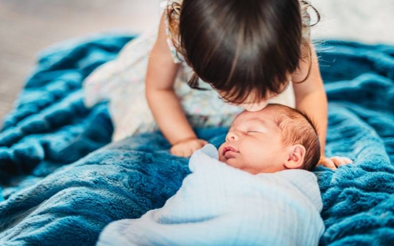 Cho trẻ đi thăm em bé mới sinh để bé tập quen dần. (Ảnh: Sưu tầm Internet)