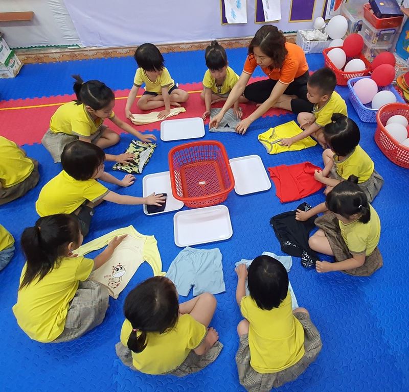 Dạy con gấp quần áo đúng cách. (Ảnh: Mầm non Quang Minh A) 