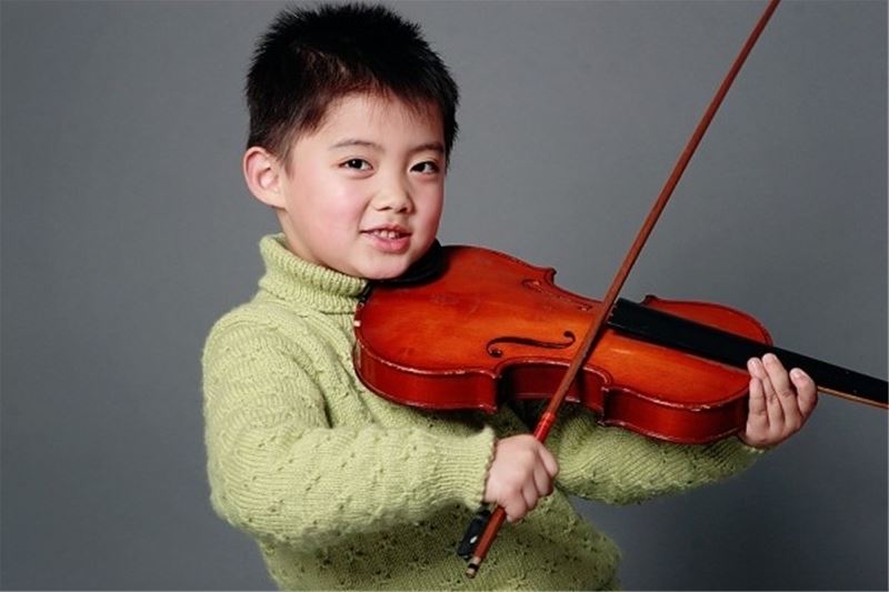 Cho con thử nghiệm nhiều loại đàn violin trước khi mua. (Ảnh: Internet)