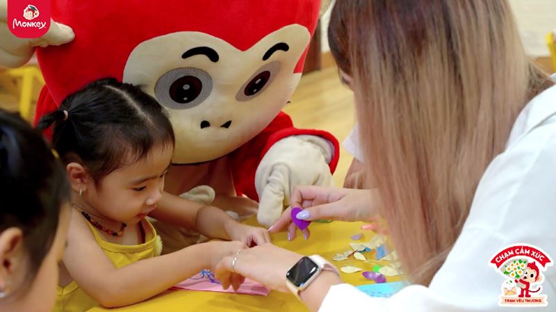 Các cô hướng dẫn bé cách làm thiệp 20/10 trong trang trí & hoàn thiện. (Ảnh: Monkey)
