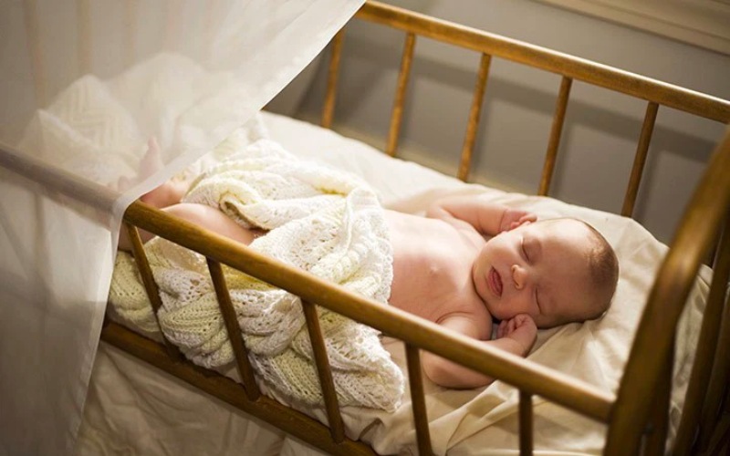 Đặt phần đầu của bé cao hơn để giúp bé hít thở dễ hơn khi ngủ (Ảnh: Sưu tầm internet)