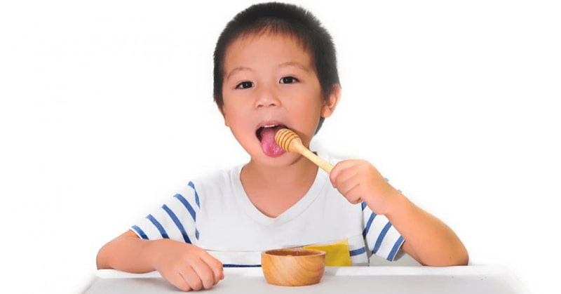 Cho bé uống mật ong trước khi ngủ để giảm tè dầm. (Ảnh: Internet)