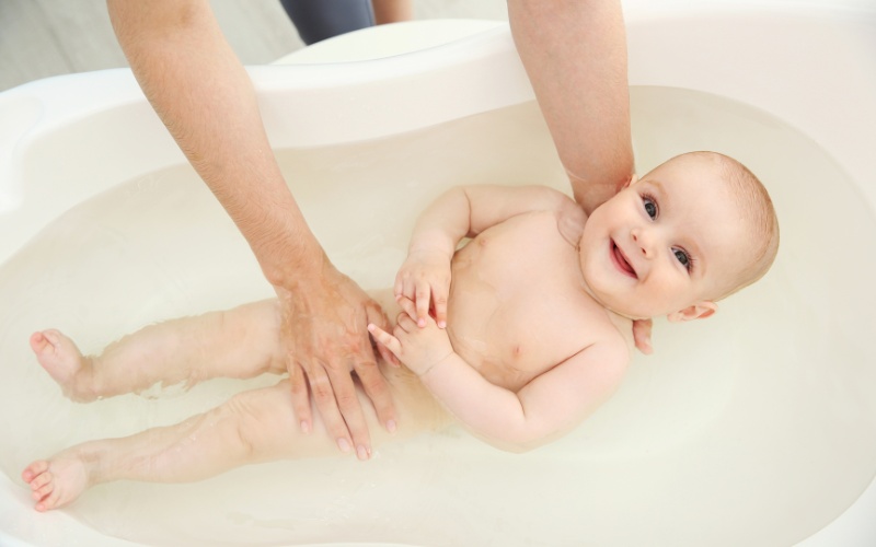 Tắm cho bé bằng nước ấm để vệ sinh cơ thể cho bé đồng thời giúp bé thoải mái hơn (Ảnh: Sưu tầm Internet)