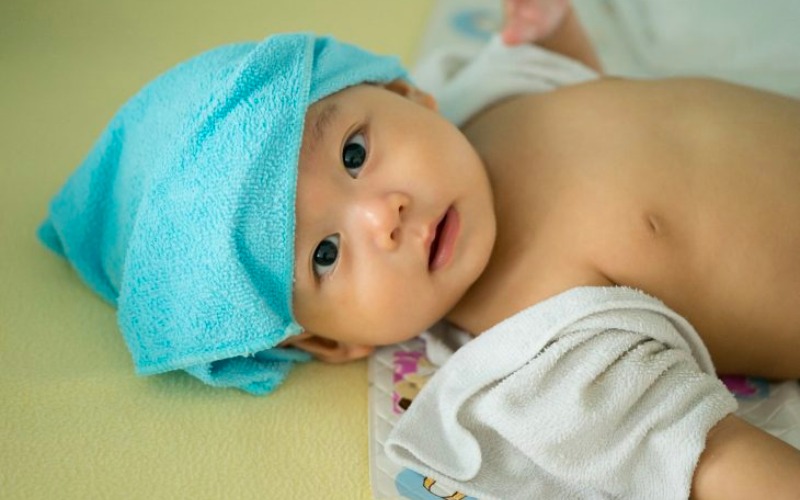Chườm khăn ấm lên vết thương của bé có thể giúp bé làm giảm cơn đau nhức (Ảnh: Sưu tầm internet)