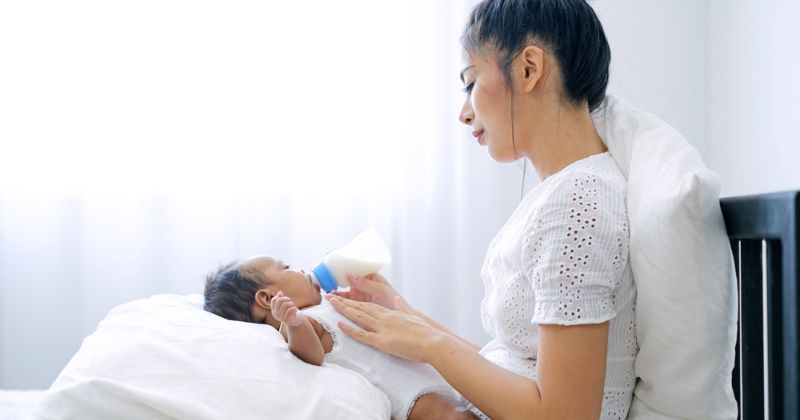 Tư thế cho trẻ bú bình dựa lưng vào đùi (Ảnh: Sưu tầm Internet)